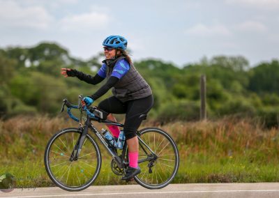 Vibrant woman cycling outdoors on Bluebonnet Express trail in Texas.