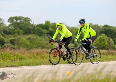 Bright yellow cycling jackets worn by two cyclists on the Bluebonnet Express bike ride outdoors.