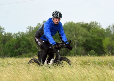 Electric bike with Bluebonnet Express branding in a grassy field, showcasing eco-friendly transportation.