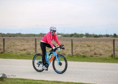 Cyclist riding a Bluebonnet Express bike in open rural area for outdoor cycling.