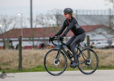 High-performance cyclist riding a bike outdoors in athletic gear for Bluebonnet Express event.