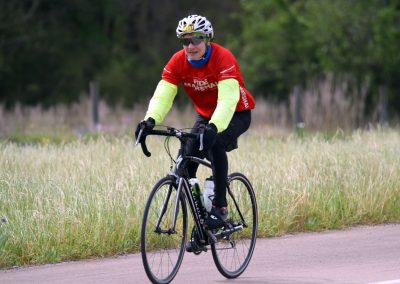 Cyclist riding a bike on a scenic trail in the countryside, promoting outdoor cycling and fitness.