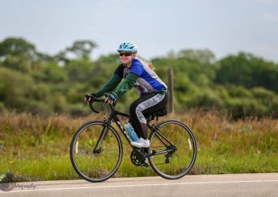 Bright young woman cycling in scenic outdoors, promoting health and eco-friendly travel.