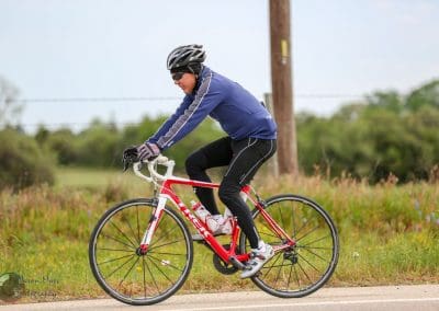 Vegan cyclist riding a red and white bike on a scenic trail in nature.