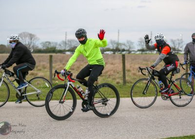 Group of cyclists riding bikes outdoors, enjoying a scenic ride during daytime.