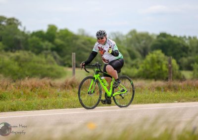 Bright green mountain bike on scenic trail with rider enjoying outdoor cycling adventure.