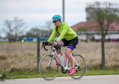 Cyclist riding a bike outdoors in bright gear on a cloudy day for the Bluebonnet Express event.