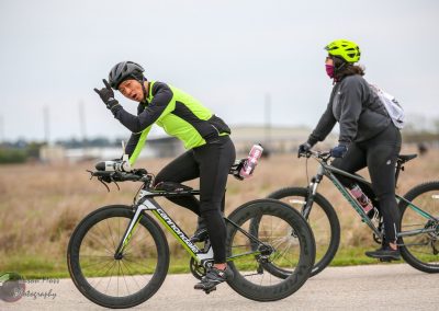 Vegan cyclists riding on a scenic trail during daytime.