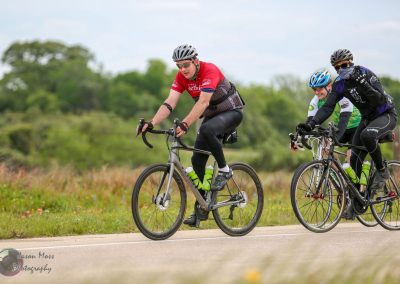 Avid cyclists riding bikes through scenic countryside on Bluebonnet Express route.