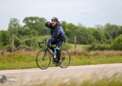 Versatile cyclist on road bike enjoying scenic outdoor ride in nature on a cloudy day.