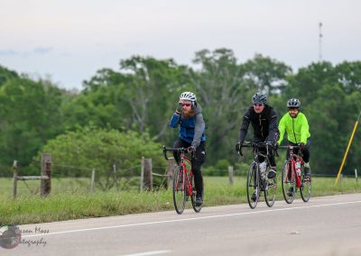 Cyclists riding on the road with lush greenery, promoting outdoor biking and eco-friendly transportation.