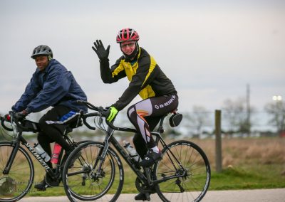 Vivid image of two cyclists enjoying a ride on a cloudy day, highlighting Bluebonnet Express cycling adventure.