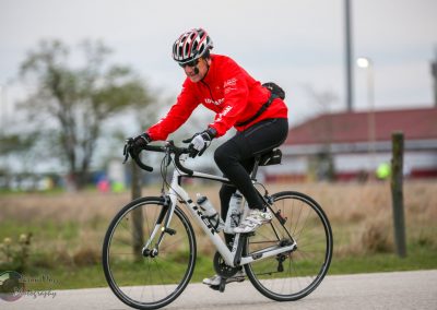 Cyclist riding an e-bike in outdoor park, promoting Bluebonnet Express bike services.