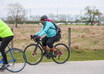Bright blue cycling jacket on woman riding bike outdoors during daytime.
