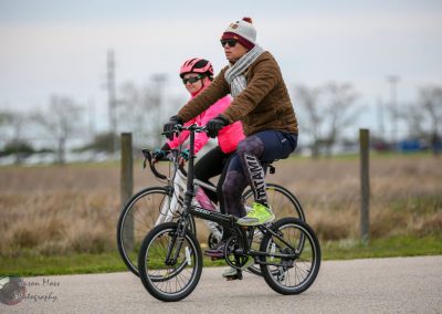 Cyclists riding on the Bluebonnet Express bike trail in mild weather, enjoying outdoor recreation.