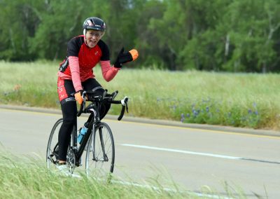 Vibrant cyclist on Bluebonnet Express bike ride in Texas wildflowers, scenic outdoor cycling adventure.