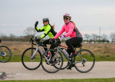 Bright women cyclists riding bikes on a scenic outdoor trail for active transportation at Bluebonnet Express.