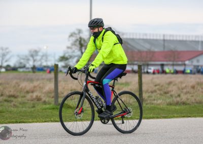 Comfortable cyclist wearing bright yellow jacket on road bike for Bluebonnet Express event.
