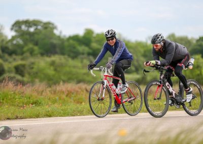 Cyclists riding together on a scenic outdoor trail promoting Bluebonnet Express bike tours and events.
