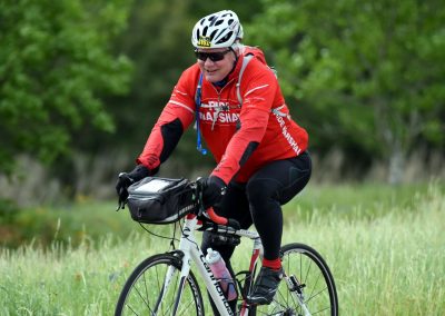 Vibrant cyclist enjoying outdoor ride on a scenic trail, promoting Bluebonnet Express bike tours and adventures.