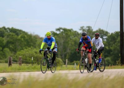 Bright blue Bike Ride with Cyclists on Scenic Road | Bluebonnet Express bike tour.