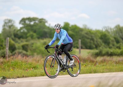 Cyclist enjoying a ride on the Bluebonnet Express bike route through scenic Texas countryside.