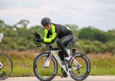 Bright yellow and black cycling gear on professional cyclist riding a Bontager bike outdoors.