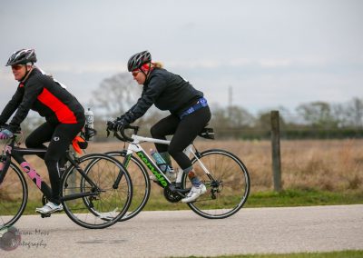 Bright Bluebonnet Express cycling event on scenic rural road, women riders cycling outdoors.