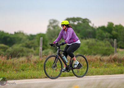 Woman riding a bicycle outdoors with a focus on local biking experience and scenic views.
