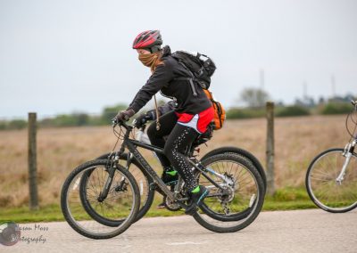Bright blue bicycle with rider on Bluebonnet Express scenic trail, cycling outdoors.