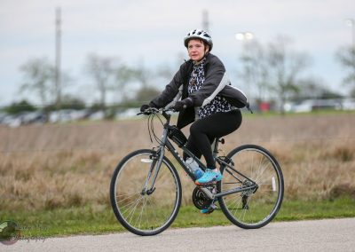 Woman riding electric bike on path, learning about Bluebonnet Express cycling tours, outdoors.
