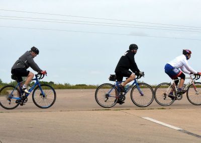 Bicycle riders wearing helmets on the road during daytime for Bluebonnet Express cycling event.