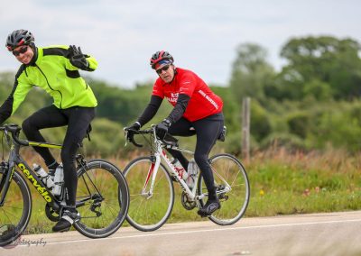 Vibrant cyclists riding on rural roads, promoting Bluebonnet Express bike tours and events.
