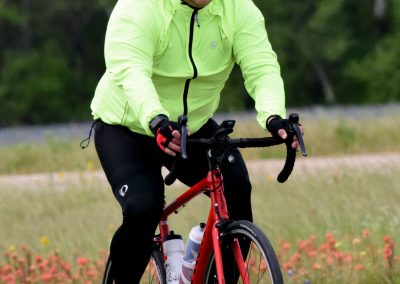 Man riding a red bicycle in outdoor trail during daytime, eco-friendly cycling activity.