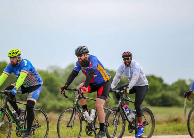 Bicycle group ride outdoors featuring cyclists in colorful jerseys and gear, promoting active lifestyle and eco-friendly travel.