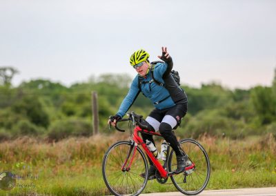 Bright yellow bike helmet, cycling safety gear, rider on road bike, outdoor bike touring, Bluebonnet Express focus.