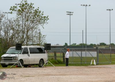 School football field setup with speakers, a vehicle, and a person preparing for the Bluebonnet Express event.