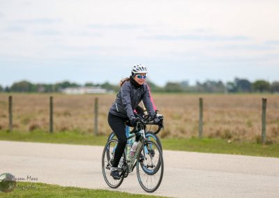 Cyclist riding a road bike in daytime, promoting Bluebonnet Express bike services.