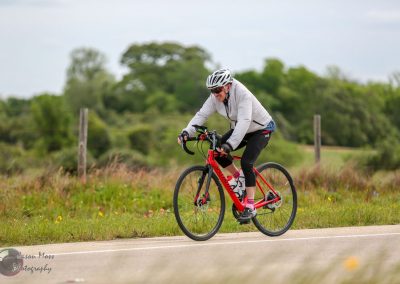 Bright red mountain bike on scenic trail with cyclist enjoying outdoor activity.
