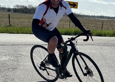 Vibrant cyclist riding a bike on a scenic outdoor road, enjoying the Bluebonnet Express trail.
