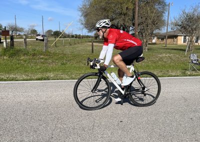Bike riding along a scenic roadside with blue sky and trees, promoting Bluebonnet Express bike transportation service.