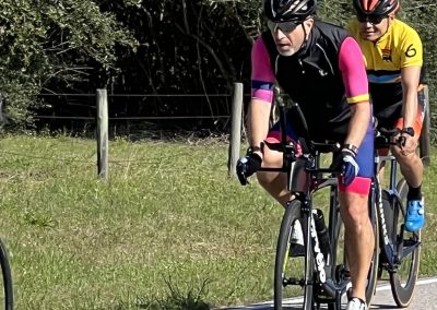 Vintage tandem bike ride featuring cyclists in colorful gear, enjoying an outdoor cycling experience.