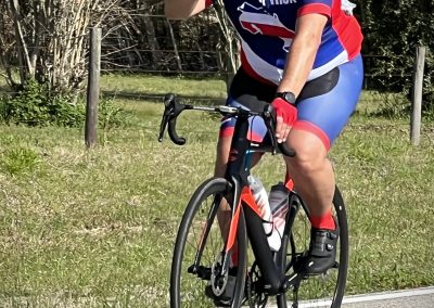 Vibrant cyclist wearing Costa Rica jersey riding a road bike outdoors during daytime.