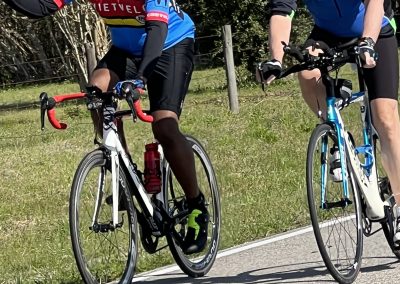 Vibrant cyclists enjoying a ride on a sunny day with lush greenery in the background.