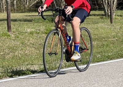 Vivid image of a cyclist riding a bike on a scenic trail with greenery, highlighting Bluebonnet Express bike routes.