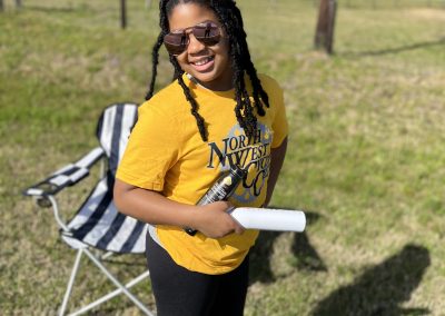 Bright young woman with dreadlocks enjoying outdoor activity, promoting eco-friendly bike rides and outdoor adventures.