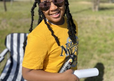 Bright smiling woman enjoying outdoor biking, wearing sunglasses and a yellow T-shirt.