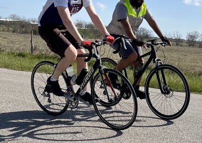 Sports cyclists riding on a rural road during daytime.
