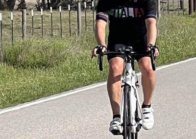 Velo cyclist riding on scenic rural road, Bluebonnet Express themed cycling event or race.