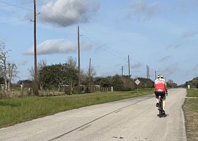 Scenic cyclist riding on a rural road, peaceful outdoor scene, Bluebonnet Express bike route.